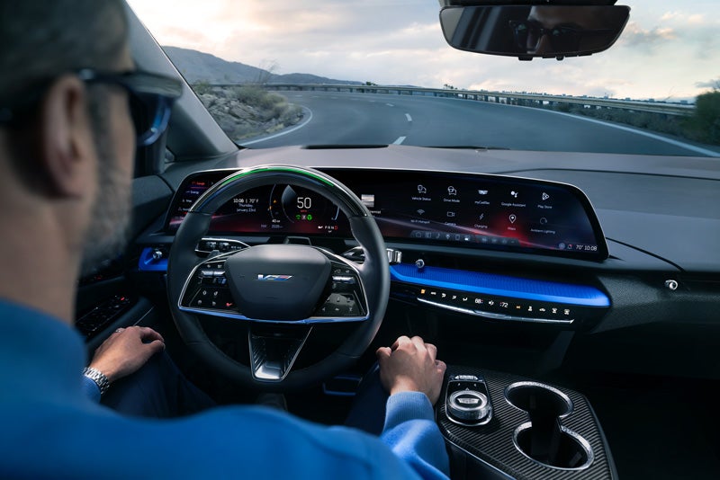 Front View of the 2026 OPTIQ-V Driving Through the Dusk Utilizing its Headlights | Vaughn Automotive - Cadillac of Ottumwa in OTTUMWA IA